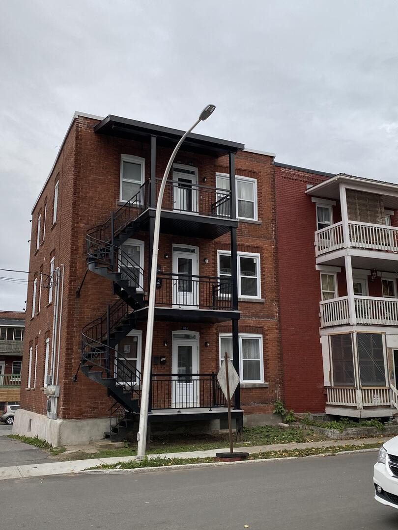 Brick triplex at 1156 Ste-Angèle in Trois-Rivières with exterior staircases and balconies
