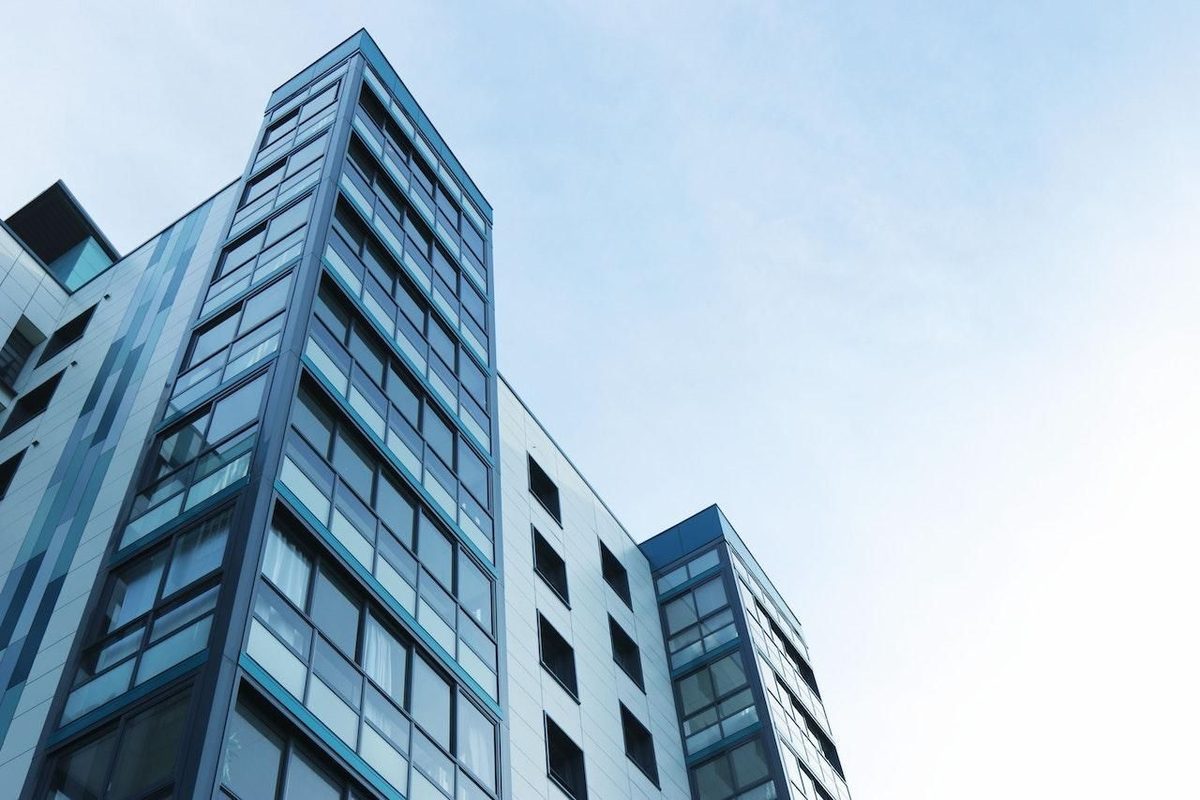Tour de bureaux vitrée vue en contre-plongée sur un ciel bleu